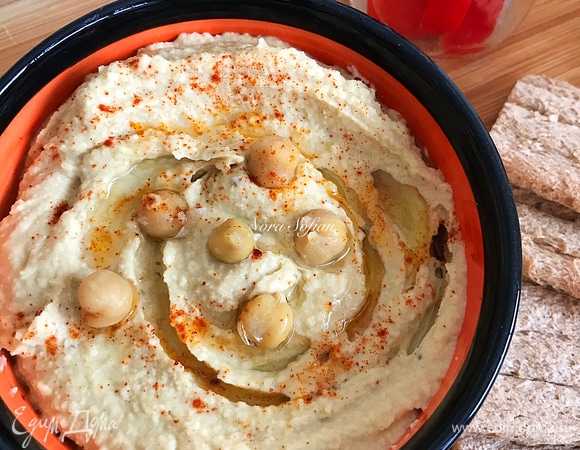 Переложить хумус в пиалу, полить оставшимся маслом и по желанию посыпать паприкой или украсить нутом.