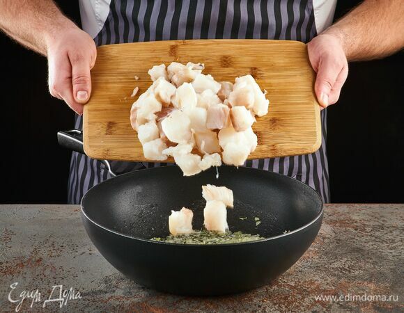 Рыбное филе освободите от костей, нарежьте крупным кубиком, выложите к луку. Добавьте соль и перец. Жарьте рыбу 5 минут до румяности.