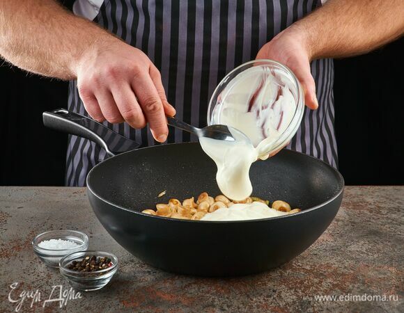 Выложите в сковороду сметану, добавьте соль и перец. Потомите на огне пару минут.