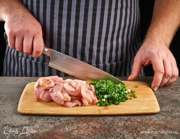 Курицу нарежьте тонкими кусочками. Зеленый лук нарежьте мелко.