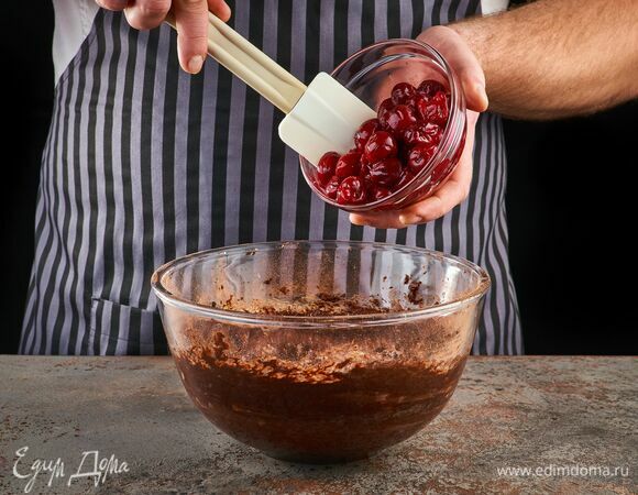 Добавьте предварительно размороженную вишню, перемешайте. Тесто переложите в форму для выпекания, застеленную пергаментом. Выпекайте брауни 20 минут при 160°C.