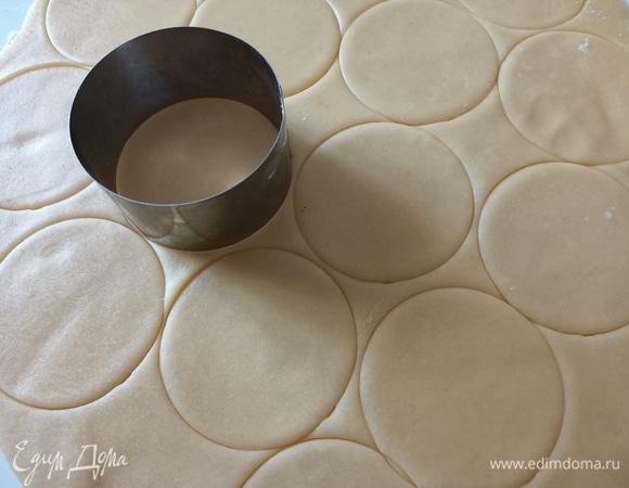 Рабочую поверхность посыпать мукой. Раскатать песочное тесто. Круглой формой диаметром 8 см вырезать заготовки для корзинок.