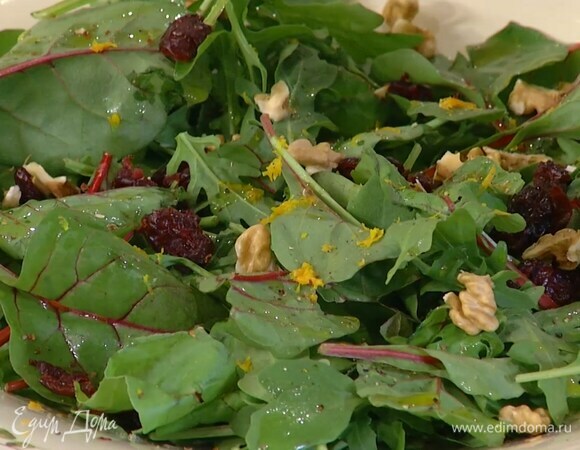 В глубокое блюдо выложить листья салата, полить их оливковым маслом и уксусом, посыпать цедрой, клюквой, грецкими орехами и свежемолотым перцем, полить все апельсиновым соком, сверху поместить отваренную рыбу.