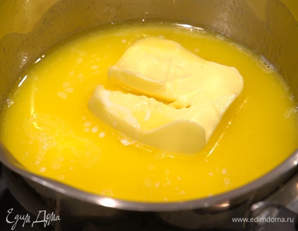 В кастрюлю выложить 150 г сливочного масла, влить молоко и растопить все на медленном огне.