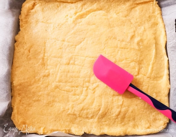 Готовую поленту переложить на противень, предварительно застелив его пергаментной бумагой. Затем быстро, пока каша не остыла, распределить ее по всей поверхности противня и дать хорошо остыть (40–50 минут).