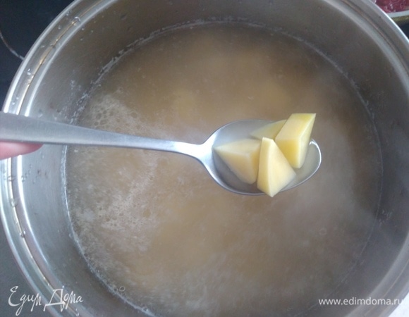 Картофель нарезать кубиками. Всыпать в бульон, варить 15 минут.