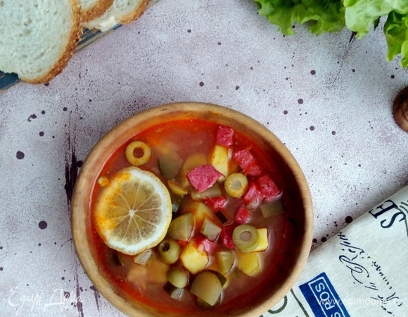 Лимон нарезать дольками. Подавать солянку с лимоном.