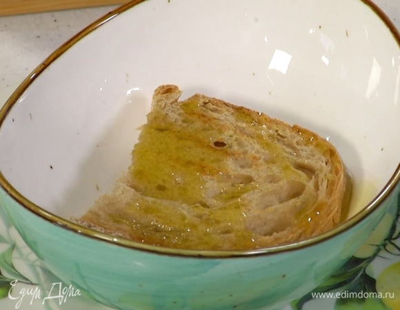 Приготовить гренки: хлеб обжаривать с двух сторон на сухой сковороде-гриль до появления румяных полосок, затем почистить оставшийся чеснок, слегка смазать им хлеб, выложить его в суповые тарелки и сбрызнуть оставшимся оливковым маслом.