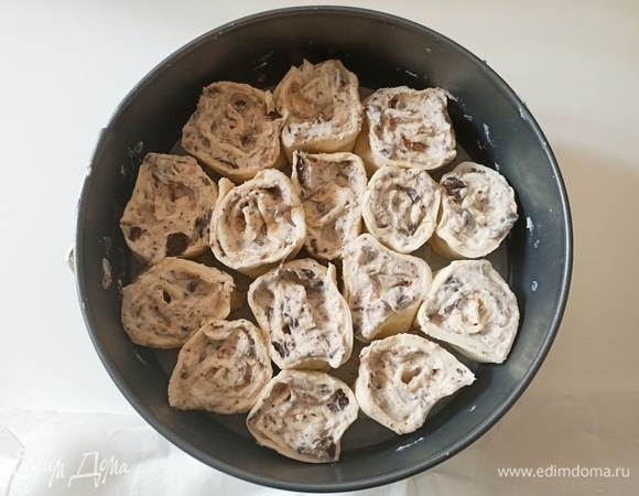 Слоеное тесто с кремом аккуратно свернуть рулетом, затем острым ножом разрезать его на мини-рулеты по 2 см и выложить их в разъемную форму.