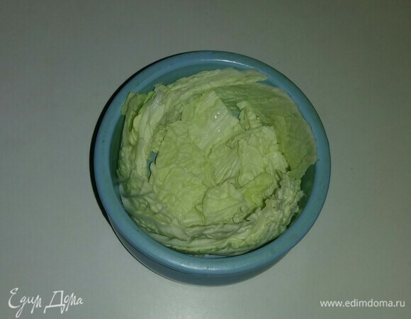 Положить на дно горшочка часть пекинской капусты, нарезанной квадратами, а вдоль стенок выложить полоски капусты.