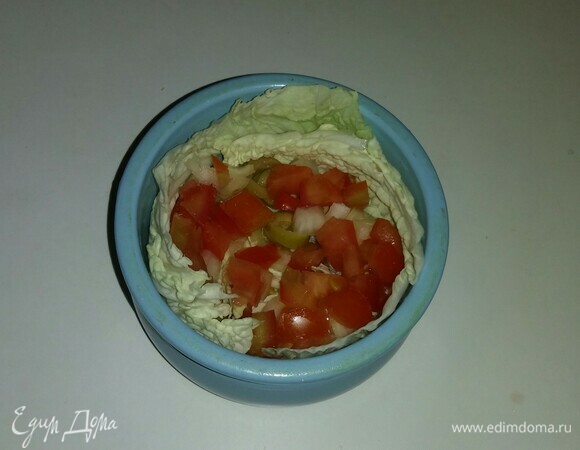 Затем выложить в горшочек на слой пекинской капусты часть нарезанного помидора, репчатого лука и оливок.