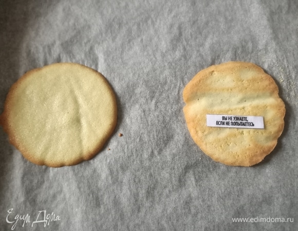 Духовку разогреть до 170°C. Выпекать печенье желательно по 2–3 штуки за раз. В течении 5–8 минут — до тех пор, пока края печенья не станут румяными. Снимать по одному за раз. Силиконовой лопаткой перевернуть печенье внутренней стороной вверх. Положить полоску с предсказаниями и сложить печенье пополам.