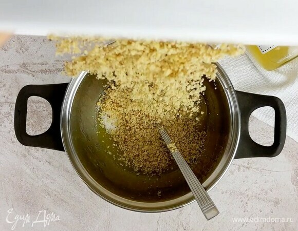 Смешиваем измельченные грецкие орехи с сахаром, растопленным сливочным маслом и жидким медом. Хорошо вымешиваем. Начинку лучше сделать прямо перед раскаткой теста.