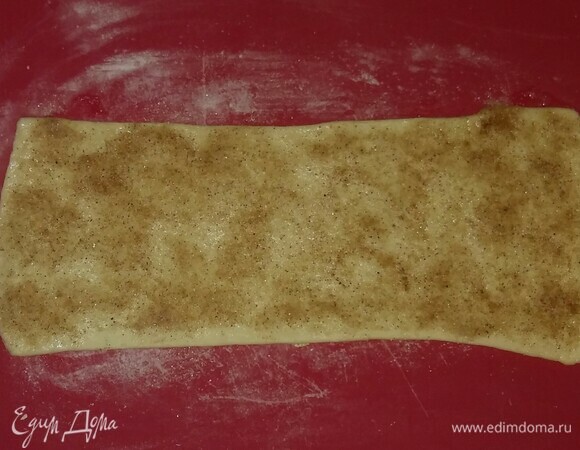 Слоеное дрожжевое тесто нужно предварительно разморозить (я использовала для приготовления печенья покупное тесто). Припылить блинной мукой рабочую поверхность, затем разделить тесто на несколько частей для удобства раскатки и раскатать тесто толщиной около 2–3 мм. Смазать тесто яичным белком, обильно посыпать смесью сахарного песка и пряничных специй. Слегка раскатать еще раз.