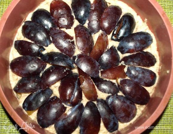 Выкладываем на тесто сливы и слегка вдавливаем их.