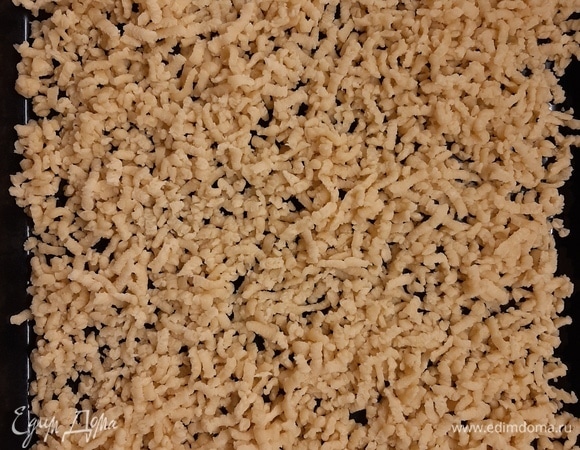 Через 1 час достать тесто из морозилки, натереть его на крупной терке на противень и выпекать в течение 10–15 минут (зависит от духовки), до золотистого цвета. Из указанного количества продуктов получилось два противня.