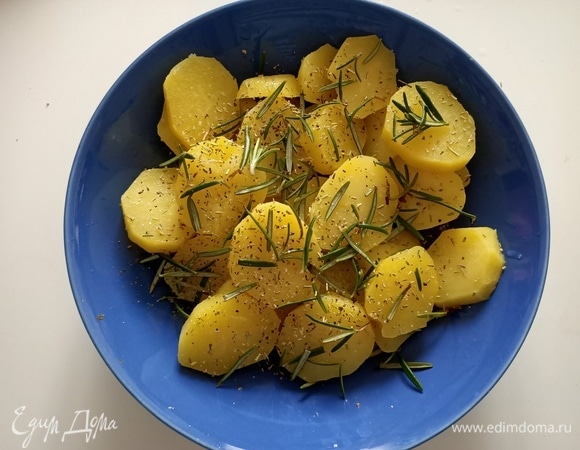 Картофель нарезать толщиной 0,5 см. Посолить, поперчить, добавить розмарин и пару ложек оливкового масла. Перемешать и оставить мариноваться.