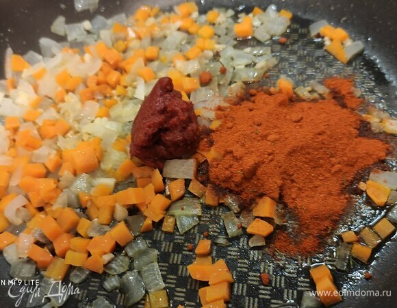 Добавить оба вида паприки и томатную пасту. Здесь я должна уточнить, что в этом случае использую порошок обеих красных паприк: сладкой и острой (в ингредиентах острую не нашла). Тщательно размешать и обжарить несколько минут с луком, морковью и чесноком.