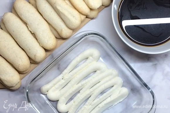 На дно формы отсаживаем слой крема. Подготовим печенье савоярди (можно использовать покупное печенье или приготовить самим).