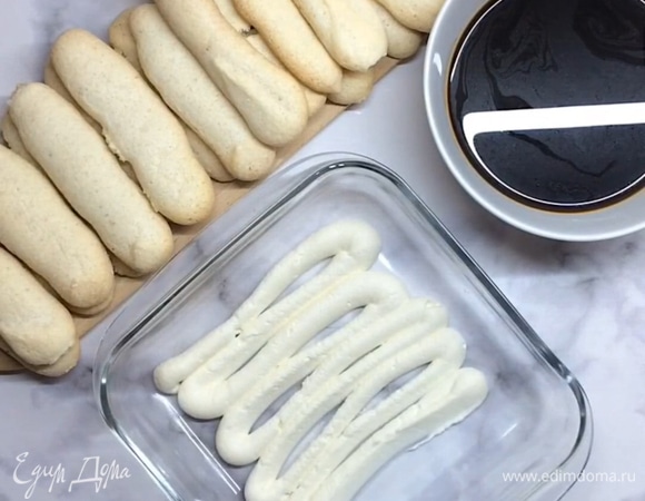 На дно формы отсаживаем слой крема. Подготовим печенье савоярди (можно использовать покупное печенье или приготовить самим).