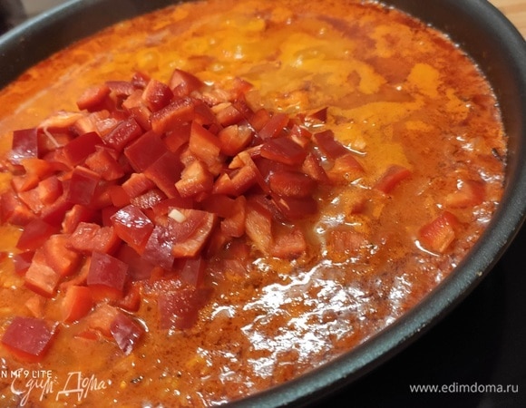 Влить бульон и добавить мелко нарезанный красный болгарский перец. Довести до кипения, уменьшить огонь и томить под крышкой около 20 минут. Нужно следить за тем, чтобы рис не подгорел, и по необходимости добавить еще жидкости. У меня длиннозерный пропаренный рис, который я использую для плова или паэльи. На упаковке указано время приготовления, оно составляет 12–15 минут, но за счет кислоты в соусе, в котором готовился рис, время приготовления увеличивается.