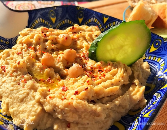 Переложить готовый хумус в посуду для подачи, полить оставшимся маслом и по желанию посыпать чили и украсить нутом.