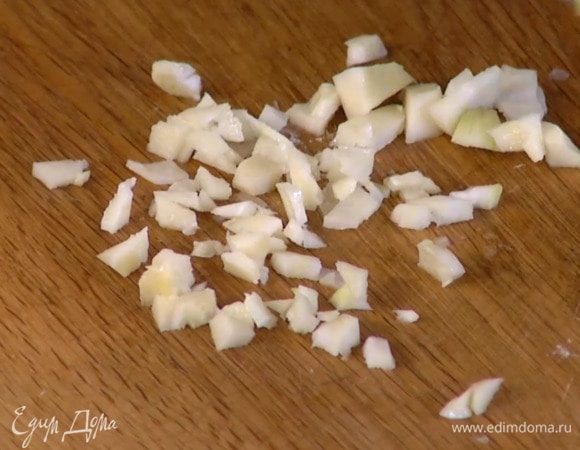 Чеснок почистить, мелко порубить, добавить в сотейник и обжарить до прозрачности.