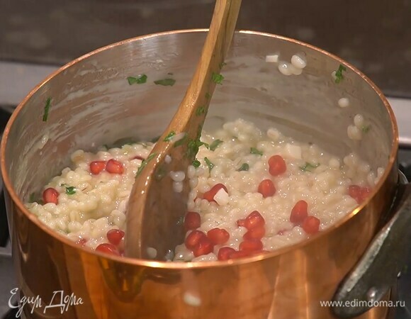 В готовое перлотто выложить оставшееся сливочное масло, все перемешать, затем добавить петрушку и зерна граната.