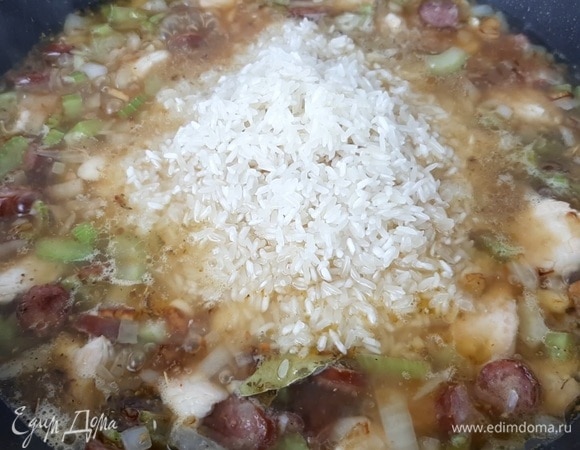 Наливаем 450 мл воды или бульона в сковороду. Рис промываем и добавляем в сковороду, аккуратно разравниваем. Накрываем крышкой и готовим на медленном огне 15 минут.