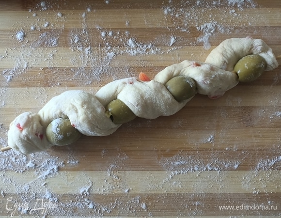 Обернуть тестом шпажку с оливками. Выложить на противень, верх смазать оливковым маслом.