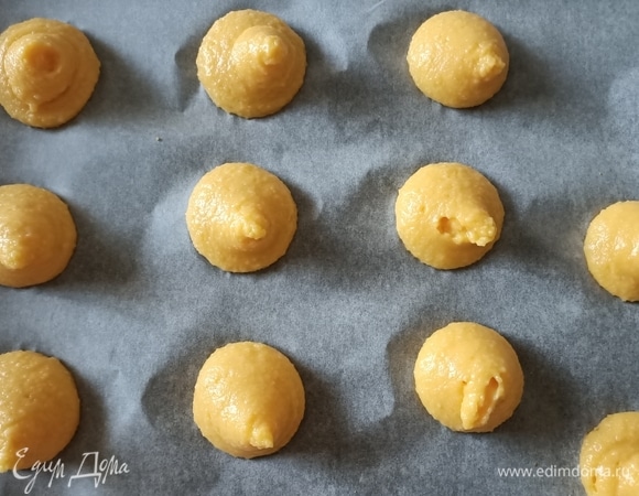В кастрюле с толстым дном нагреть воду, добавить сливочное масло и щепотку соли. Когда масло полностью растает, добавить муку и варить смесь до тех пор, пока она не станет отходить от стенок кастрюли. Снять с огня и дать остыть. Затем ввести по одному яйцу и маленькую щепотку соды. Хорошо перемешать, пока тесто не станет гладким и однородным. Тесто переложить в кондитерский мешок и выдавить небольшими порциями на противень.