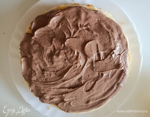 На крем уложить слоеный корж и сверху выложить половину шоколадного крема.