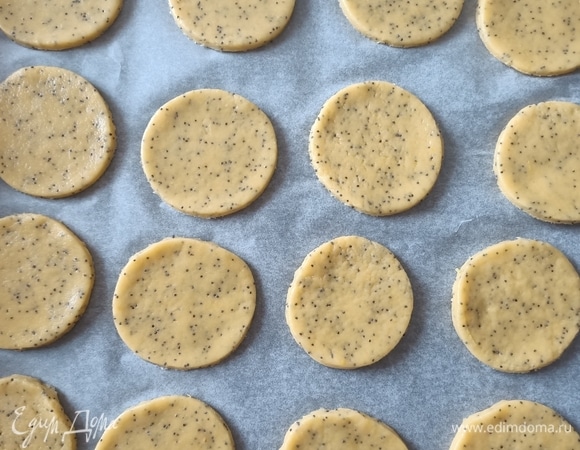 Раскатать тесто, с помощью круглой формы вырезать заготовки для будущего печенья. Противень застелить пергаментной бумагой выложить тесто и поставить в предварительно разогретую до 180°C духовку примерно на 10 минут, пока печенье не станет слегка золотистого цвета.