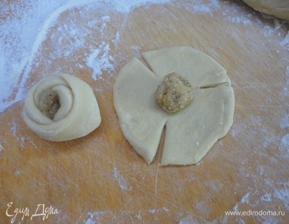 На кружочки из теста выложить начинку (примерно с грецкий орех), сделать три надреза и свернуть розочкой.
