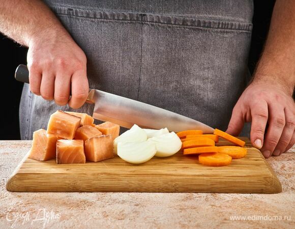 Нарежьте рыбу порционными кусочками. Лук разрежьте пополам, морковь нарежьте кружочками.