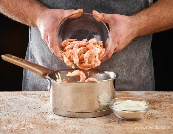 Добавьте креветки, муку и слегка обжарьте.