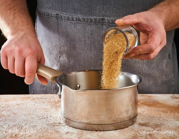 Приготовьте соус. В сотейник высыпьте сахар. Расплавьте сахар на небольшом огне, постоянно помешивая. Следите, чтобы он не подгорел.