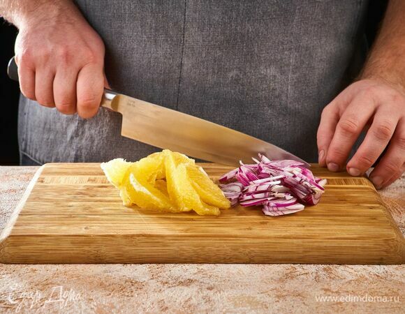 Красный лук нарежьте тонкими полукольцами. Апельсин очистите, разделите на дольки.