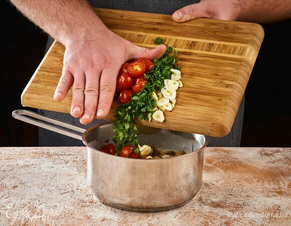 Выложите в сотейник петрушку, чеснок, помидоры. Готовьте на среднем огне 5 минут.