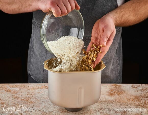 В чашу хлебопечки STARWIND влейте жидкую массу. Сверху высыпьте мучную смесь и орехи.