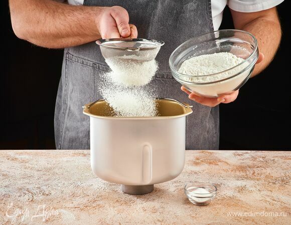 Пшеничную муку просейте с разрыхлителем теста. Высыпьте в чашу хлебопечки STARWIND.