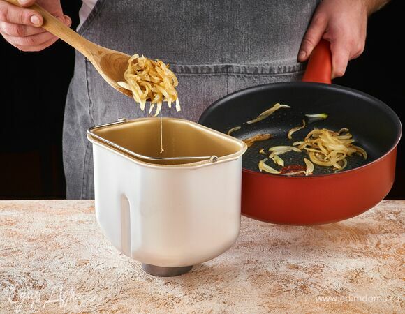 Добавьте в чашу хлебопечки обжаренный лук.