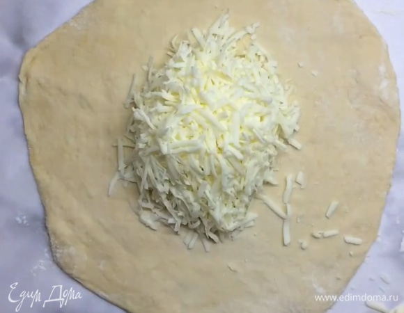 Натираем сыр на крупной терке. Раскатываем тесто не слишком тонко, чтобы получился круг. Выкладываем часть начинки в середину.