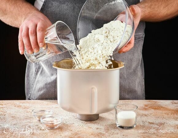 В чашу хлебопечки STARWIND влейте воду, добавьте сахар, соль, пшеничную муку и дрожжи.