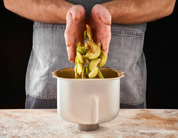 Яблоки нарежьте тонкими пластинками. В чашу хлебопечки STARWIND выложите половину яблок.