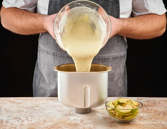 Сверху влейте половину теста. Далее еще слой яблок и слой теста.