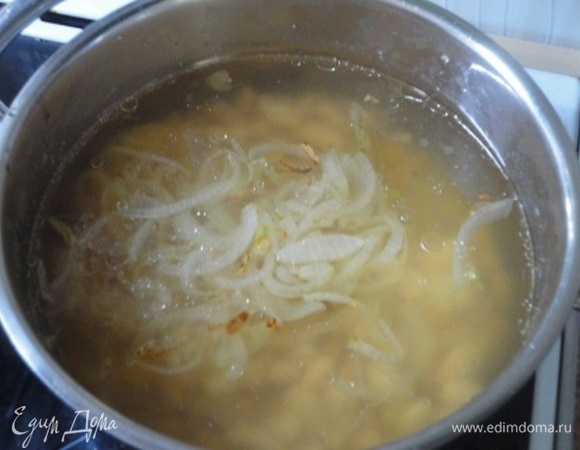 Лук обжарить на оливковом масле до золотистого цвета и выложить к фасоли.