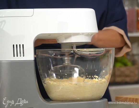 Приготовить тесто: предварительно размягченное сливочное масло и сахар поместить в чашу комбайна и взбить. Не выключая комбайна, по одному ввести яйца, несколько ложек муки, добавить миндальный экстракт и цедру, затем, немного уменьшив скорость, частями всыпать большую часть муки. Добавить йогурт, соль, оставшуюся муку и взбивать, пока не получится однородная воздушная масса.