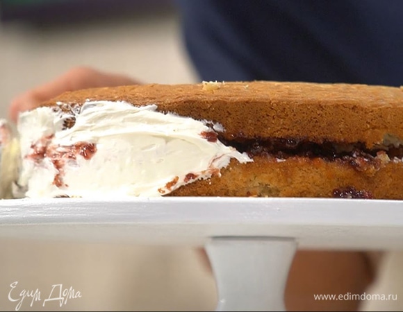 Готовый корж остудить, разрезать вдоль на 2 части. Нижний слой промазать вареньем, сверху равномерно выложить слой сливочного крема, накрыть второй половиной коржа, оставшимся кремом промазать бока торта.