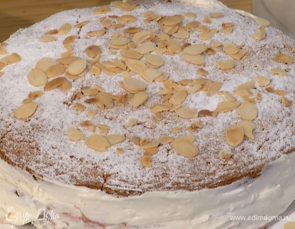 Посыпать торт оставшейся сахарной пудрой, украсить миндальными лепестками.